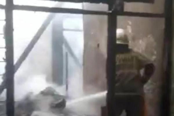 Seorang petugas pemadam kebakaran tengah berupaya memadamkan api yang menghanguskan rumah di Kalideres (Foto: Dok. ANTARA) 
