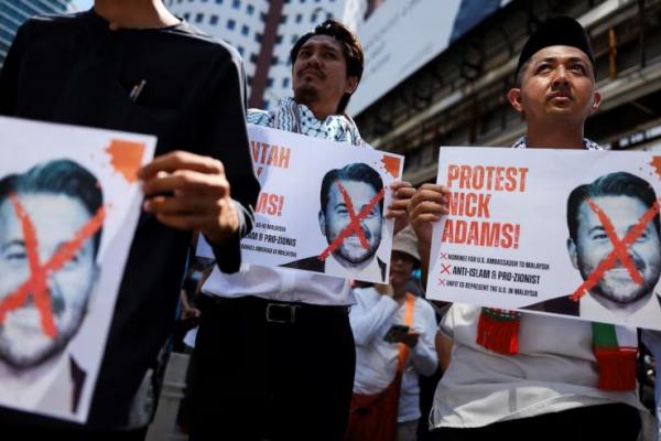 Para pengunjuk rasa memegang foto Nick Adams saat memprotes pencalonan Nick oleh Presiden AS Donald Trump sebagai duta besar AS untuk Malaysia, di luar Kedutaan Besar AS di Kuala Lumpur, Malaysia, 18 Juli 2025. REUTERS 