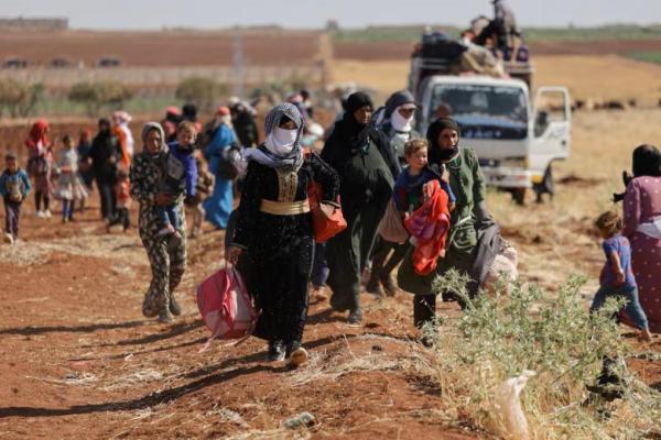 Perempuan dan anak-anak berjalan di daratan antara Deraa dan Sweida, di Deraa, Suriah, 17 Juli 2025. REUTERS 