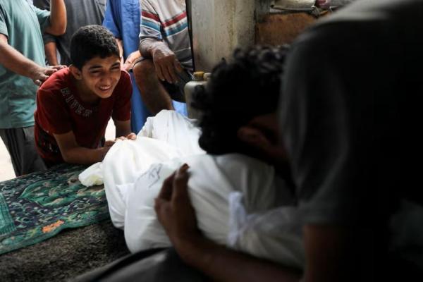 Para pelayat bereaksi di samping jenazah saat pemakaman warga Palestina yang tewas dalam serangan Israel dini hari, di Rumah Sakit Al-Shifa di Kota Gaza, 19 Juli 2025. REUTERS 