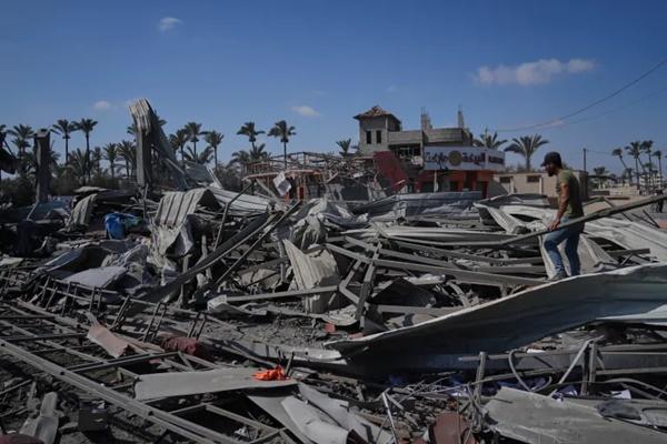Warga Palestina memeriksa reruntuhan pom bensin yang hancur akibat serangan udara Israel di Deir el-Balah, Gaza tengah. (FOTO: AP) 