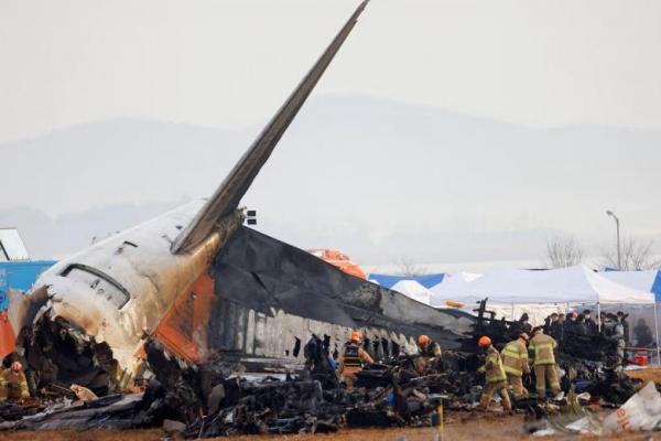 Orang-orang bekerja di lokasi kecelakaan pesawat keluar landasan pacu dan jatuh di Bandara Internasional Muan, di Muan, Korea Selatan, 30 Desember 2024. REUTERS 