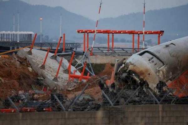 Puing-puing pesawat Jeju Air yang keluar landasan pacu dan jatuh di Bandara Internasional Muan berada di dekat struktur beton yang ditabraknya, di Muan, Korea Selatan, 30 Desember 2024. REUTERS 