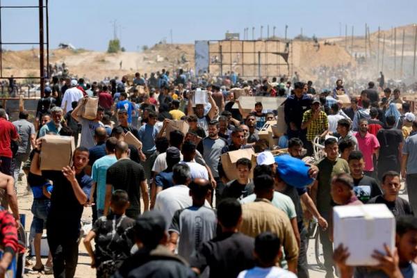 Warga Palestina membawa pasokan bantuan yang mereka terima dari Yayasan Kemanusiaan Gaza yang didukung AS, di Jalur Gaza tengah, 29 Mei 2025. REUTERS 