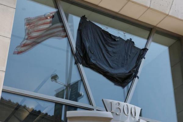 Bendera AS terpantul di jendela bekas kantor USAID yang telah ditutup di Washington, AS, 22 Juli 2025. REUTERS 
