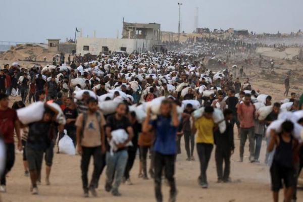 Warga Palestina membawa pasokan bantuan yang memasuki Gaza dengan truk melalui Israel, di Beit Lahia, di Jalur Gaza utara, 29 Juli 2025. REUTERS 