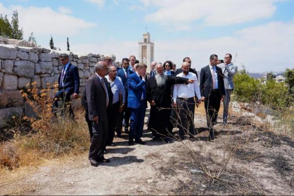 Menteri Luar Negeri Jerman Johann Wadephul mendengarkan seorang pendeta selama kunjungan ke kota Taybeh, sebuah desa Kristen di Tepi Barat yang diduduki Israel, menyusul serangan pemukim, 1 Agustus 2025. REUTERS 