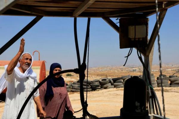 Warga Palestina, Mohammad Moghannam, di dekat tangki air yang rusak setelah serangan pemukim Israel di Susiya, dekat Hebron, Tepi Barat yang diduduki Israel, 22 Juli 2025. REUTERS 