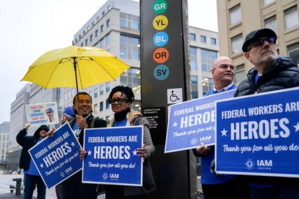 Anggota serikat buruh memegang plakat pada hari aksi unjuk rasa untuk mendukung pegawai federal di luar Stasiun Metro di Washington, AS, 24 Maret 2025. REUTERS 