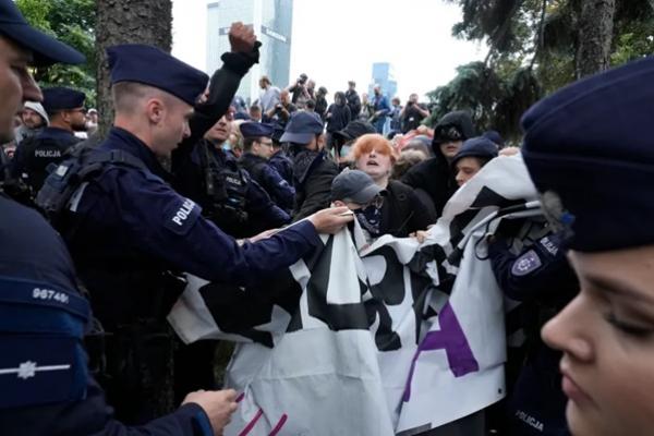 Petugas polisi berusaha memisahkan dan mengamankan sekelompok kecil demonstran tandingan yang berupaya memblokir demonstrasi anti-imigrasi di Warsawa, Polandia, pada Sabtu, 19 Juli 2025. (FOTO: AP) 