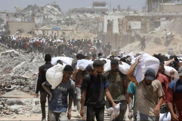 Warga Palestina membawa pasokan bantuan yang masuk ke Gaza melalui Israel, di Beit Lahia di Jalur Gaza utara, 1 Agustus 2025. REUTERS 