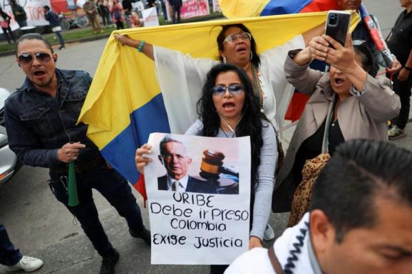 Orang-orang memprotes Presiden Kolombia Alvaro Uribe di luar kompleks peradilan Paloquemao, setelah vonis pidananya, di Bogota, Kolombia, 1 Agustus 2025. REUTERS 