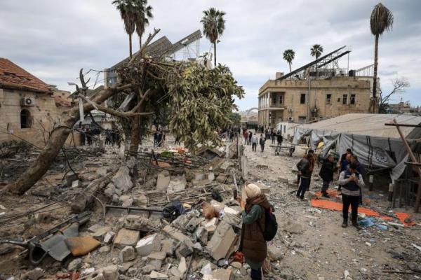Warga Palestina memeriksa kerusakan setelah dua rudal Israel menghantam sebuah gedung di dalam Rumah Sakit Baptis Arab Al-Ahli, di Kota Gaza, 13 April 2025. REUTERS 