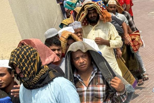 Orang-orang menutupi kepala mereka dengan sajadah untuk berteduh, setelah salat Jumat, di tengah teriknya musim panas di Dubai, Uni Emirat Arab, 1 Agustus 2025. REUTERS 