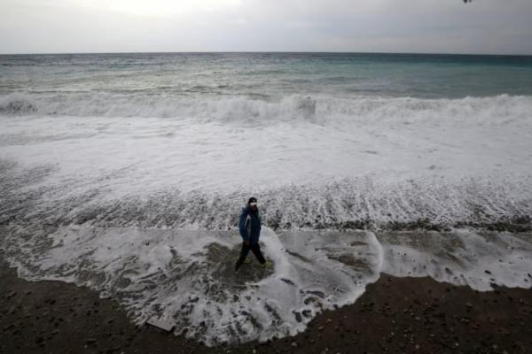 Seorang pria berjalan di pantai Nice saat badai dan hujan deras melanda Prancis selatan, 23 Oktober 2019. REUTERS 