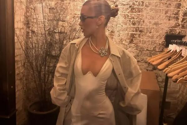 Bella Hadid mengenakan gaun sutra putih berpotongan rendah saat menggoda penggemar dengan peluncuran parfum Orebella terbaru. (FOTO: INSTAGRAM) 