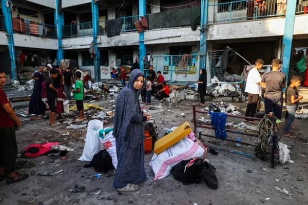 Warga Palestina menyelamatkan barang-barang dari reruntuhan tenda yang terkena serangan Israel sehari sebelumnya, di sekolah khusus perempuan Abu Helou yang dikelola UNRWA di kamp pengungsi Bureij di Jalur Gaza tengah pada 17 Juli 2025. (FOTO: AFP) 