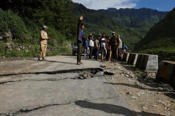 Orang-orang berdiri di jalan yang rusak setelah tanah longsor di desa Bhatwadi di distrik Uttarkashi, Uttarakhand, India, 7 Agustus 2025. REUTERS 