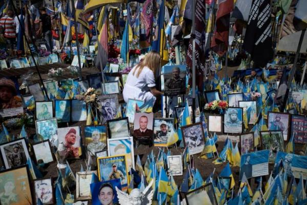 Seorang perempuan memberikan penghormatan di tugu peringatan untuk para prajurit yang gugur dalam konflik yang sedang berlangsung dengan Rusia, di Lapangan Kemerdekaan di Kyiv, Ukraina, 9 Agustus 2025. REUTERS 