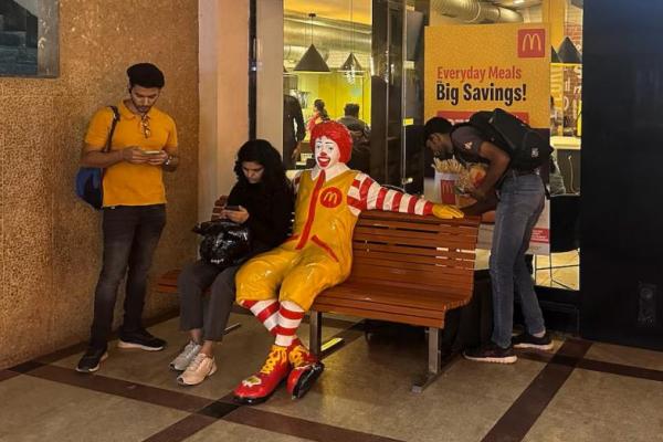 Seseorang duduk di luar restoran McDonalds di Mumbai, India, 26 Februari 2024. REUTERS 