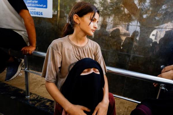 Saudari perempuan warga Palestina, Mohammed Qandeel, yang tewas dalam tembakan Israel saat mencari bantuan pada hari Sabtu, berduka saat pemakaman sang suami di Kota Gaza, 10 Agustus 2025. REUTERS 