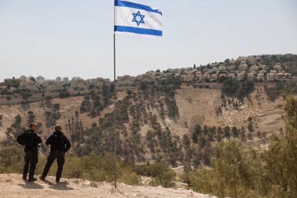 Bendera Israel berkibar, sementara sebagian permukiman Israel di Maale Adumim terlihat di latar belakang, di Tepi Barat yang diduduki Israel, 14 Agustus 2025. REUTERS 