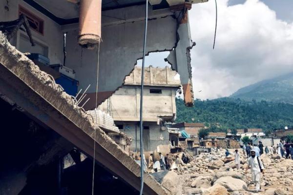 Pria berjalan melewati rumah-rumah yang rusak akibat hujan lebat dan banjir di distrik Buner, provinsi Khyber Pakhtunkhwa, Pakistan, 16 Agustus 2025. REUTERS 