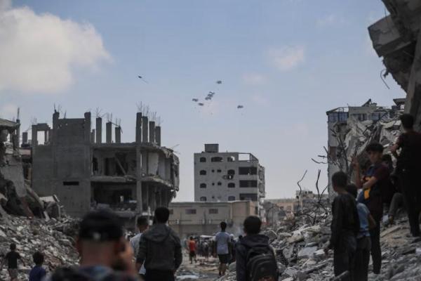 Warga Palestina melihat paket bantuan yang dijatuhkan dari udara di atas Gaza, di Kota Gaza, 8 Agustus 2025. REUTERS 