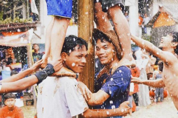 Sejumlah warga memeriahkan Hari Kemerdekaan Indonesia dengan menggelar lomba panjat pinang (Foto: Unsplash/Firas Wardhana) 