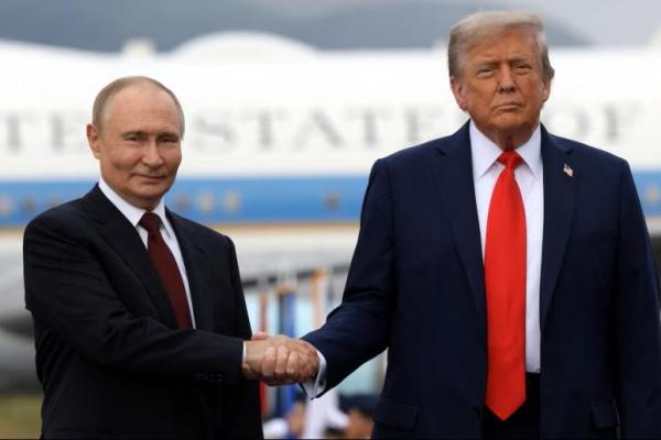 Presiden Rusia Vladimir Putin dan Presiden AS Donald Trump berpose di podium landasan pacu setelah tiba untuk menghadiri pertemuan di Pangkalan Gabungan Elmendorf-Richardson di Anchorage, Alaska, AS, 15 Agustus 2025. Sputnik via REUTERS 