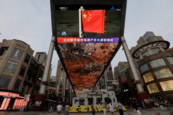 Layar besar menampilkan cuplikan berita bendera nasional Tiongkok yang dibawa oleh wahana pendarat Change-6 di sisi terjauh bulan, di Beijing, Tiongkok, 4 Juni 2024. REUTERS 