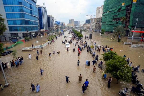 Orang-orang berjalan di jalan yang tergenang banjir setelah hujan monsun di Karachi, Pakistan, 19 Agustus 2025. REUTERS 