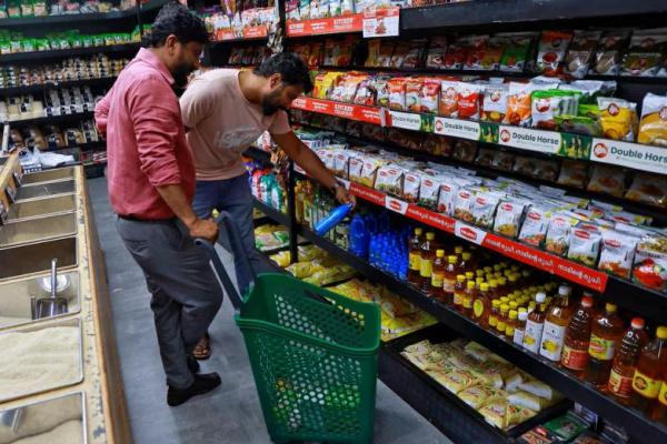 Seorang pelanggan memeriksa botol minyak kelapa sebelum membelinya di sebuah toko ritel di Kochi, India, 23 Juli 2025. REUTERS 