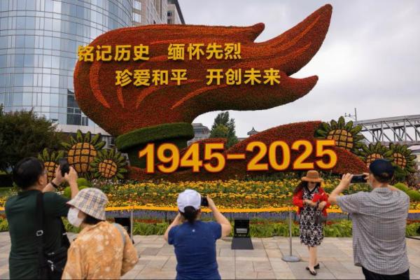 Orang-orang mengambil gambar instalasi bunga untuk memperingati 80 tahun berakhirnya Perang Dunia II, di Beijing, Tiongkok, 18 Agustus 2025. REUTERS 