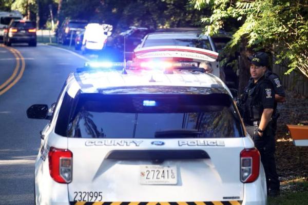 Petugas polisi berdiri di luar rumah mantan penasihat keamanan nasional Gedung Putih, John Bolton, saat digeledah oleh anggota FBI, di Bethesda, Maryland, AS, 22 Agustus 2025. REUTERS 