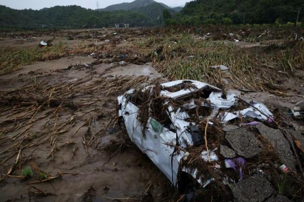 Sebuah mobil yang rusak tergeletak di ladang jagung di sepanjang tepi Sungai Liuli, distrik Huairou, Beijing, Tiongkok, 13 Agustus 2025. REUTERS 