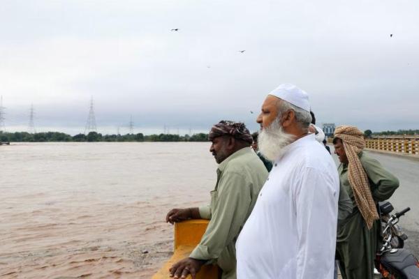 Pria berdiri di jembatan di atas Sungai Chenab, menyusul hujan monsun dan naiknya permukaan air di Wazirabad, Provinsi Punjab, Pakistan, 27 Agustus 2025. REUTERS 