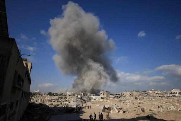 Warga Palestina berkumpul di dekat pemakaman saat asap mengepul setelah ledakan selama operasi Israel di Kota Gaza, 28 Agustus 2025. REUTERS 