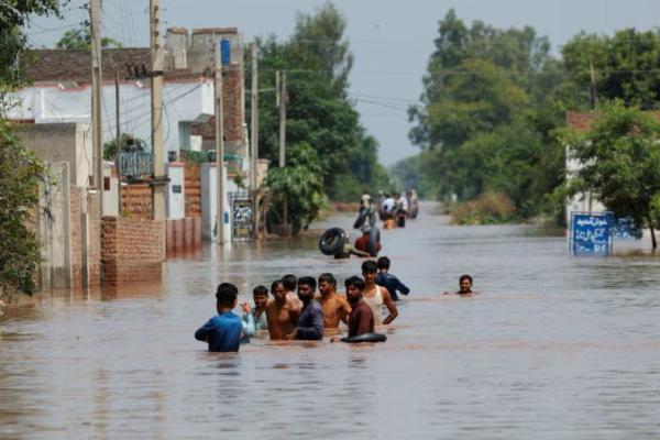 Warga mengarungi jalan yang tergenang banjir, menyusul hujan monsun di desa Qadirabad dekat Sungai Chenab di provinsi Punjab, Pakistan, 28 Agustus 2025. REUTERS 