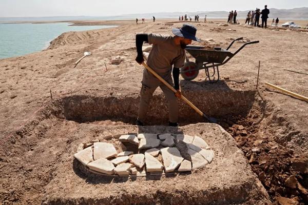Seorang pria bekerja di makam yang digali di tepi Bendungan Mosul di situs arkeologi di sub-distrik Khanke, Provinsi Dohuk, Irak, 30 Agustus 2025. (FOTO: AFP) 