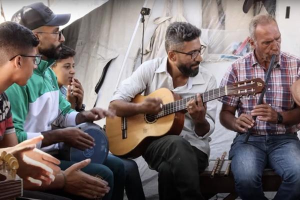 Guru musik Ahmed Abu Amsha tampil untuk anak-anak dan orang dewasa di Gaza. (FOTO: YOUTUBE/PBB) 