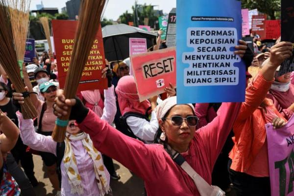 Perempuan yang mengangkat sapu dan plakat menghadiri aksi protes menentang fasilitas anggota parlemen dan kebrutalan polisi, di luar gedung DPR di Jakarta, Indonesia, 3 September 2025. REUTERS 