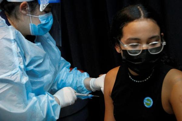 Seorang gadis diimunisasi terhadap penyakit virus corona di FTX Arena di Miami, Florida, AS, 5 Agustus 2021. REUTERS 