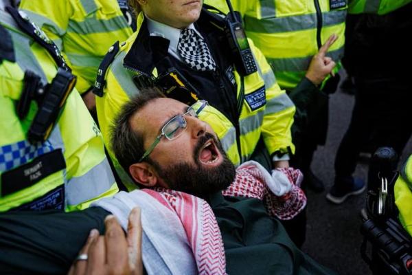 Petugas polisi menahan seorang demonstran yang diselenggarakan oleh Defend Our Juries, yang menentang larangan pemerintah Inggris atas Palestina Action, di Parliament Square, London, Inggris, 6 September 2025. REUTERS 