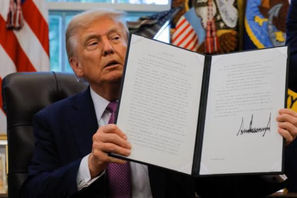 Presiden AS Donald Trump menunjukkan perintah eksekutif yang ditandatangani untuk mengganti nama Departemen Pertahanan menjadi Departemen Perang, di Ruang Oval, Gedung Putih di Washington, AS, 5 September 2025. REUTERS 