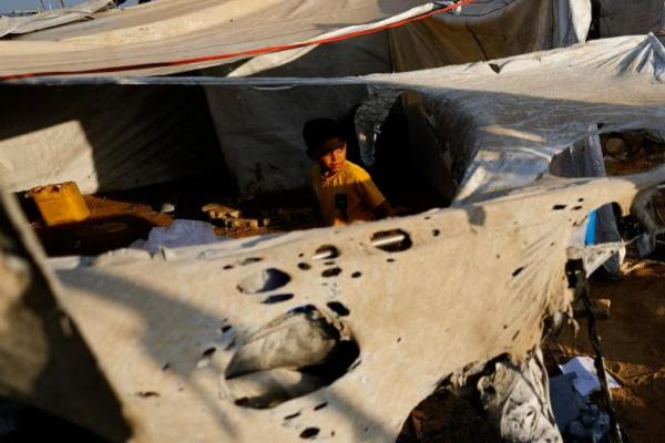 Seorang anak memperhatikan warga Palestina memeriksa lokasi serangan Israel semalam terhadap sebuah tenda, di Kota Gaza, 8 September 2025. REUTERS 