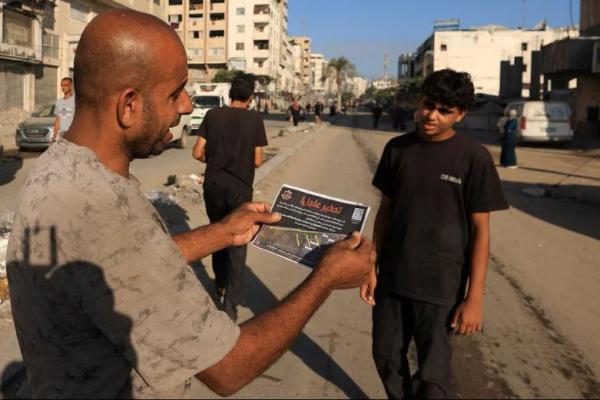 Seorang pria Palestina memegang selebaran yang dijatuhkan oleh pasukan Israel yang memerintahkan penduduk untuk mengungsi, di Kota Gaza, 9 September 2025. REUTERS 