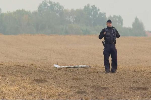 Seorang petugas polisi Polandia berdiri di dekat pecahan pesawat tanpa awak di Czesniki, Provinsi Lublin, Polandia, 10 September 2025 dalam gambar diam dari video ini. Polsat News via REUTERS 