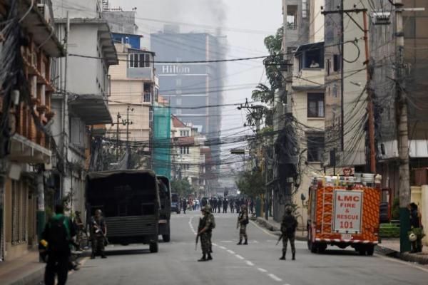Tentara Nepal berjaga-jaga saat asap mengepul dari Hotel Hilton, menyusul protes antikorupsi yang dipicu oleh larangan media sosial yang kemudian dicabut, di Kathmandu, Nepal, 10 September 2025. REUTERS 