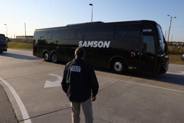 Seorang petugas polisi Departemen Keamanan Dalam Negeri mengarahkan bus-bus yang mengangkut pekerja yang ditahan, di Atlanta, Georgia, AS, 11 September 2025. REUTERS 